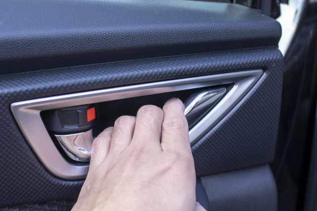 車内からドアレバーを操作する様子。周囲の安全を確認しながらドアを開ける動作の解説。