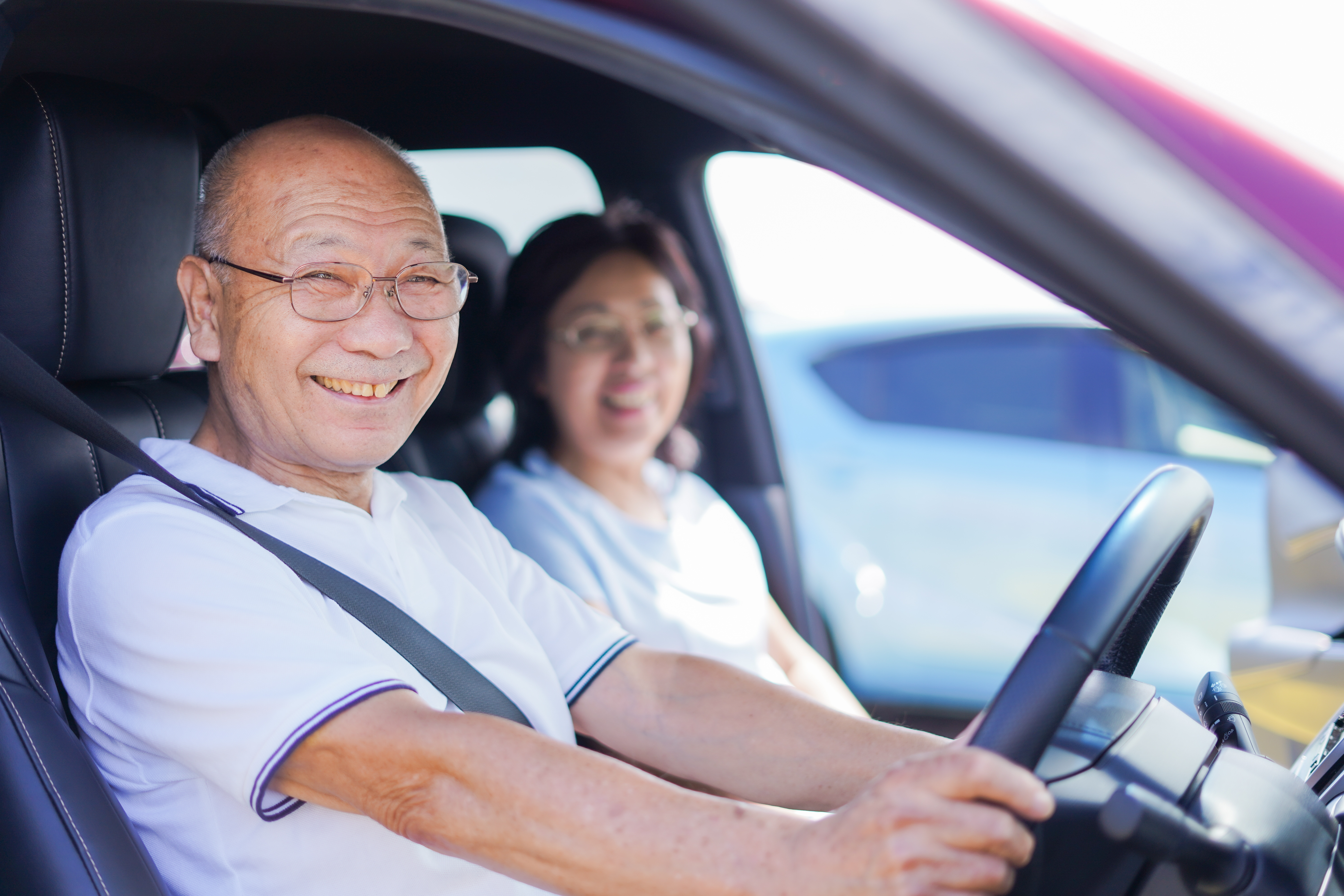ペーパードライバー講習 笑顔で車を運転する高齢男性と女性