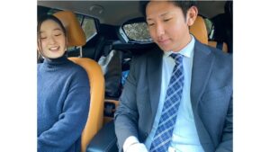 オフィシャルドライブ鹿児島のペーパードライバー講習で、車内にて笑顔でインストラクターの説明を聞く受講生の様子