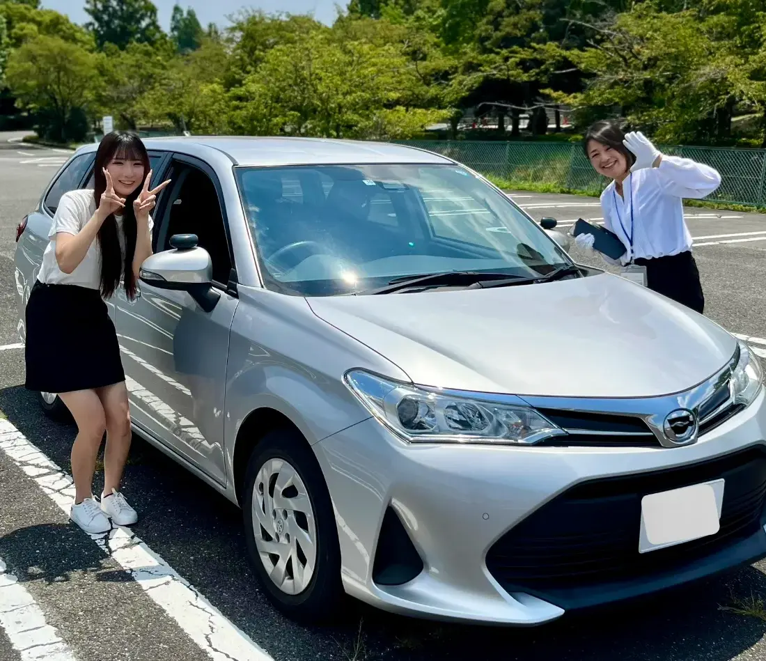 ペーパードライバー講習 出張教習ハーモニー:車の前で笑顔の受講生とインストラクター