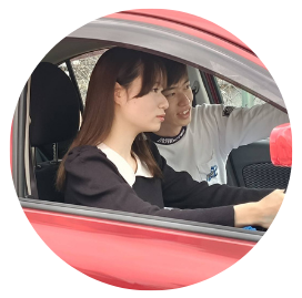 自動車のペーパードライバー講習で実践的な運転指導を行う様子。助手席から優しく的確にアドバイスを送るタイヨウセーフティードライブ・タイヨウライディングスクール代表の志村太陽先生と、落ち着いてハンドルを握る女性の生徒さん